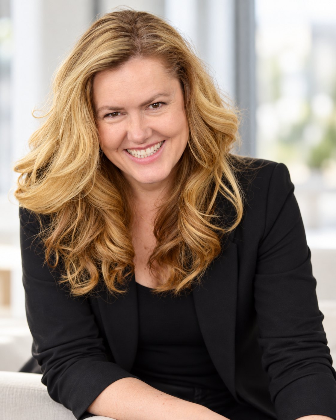 Adela Grama, smiling, in a black blazer